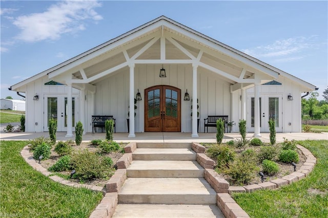 view of exterior entry featuring french doors and board and batten siding