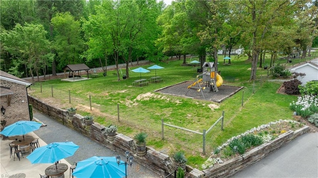 view of community featuring a gazebo, a patio, a lawn, and a playground