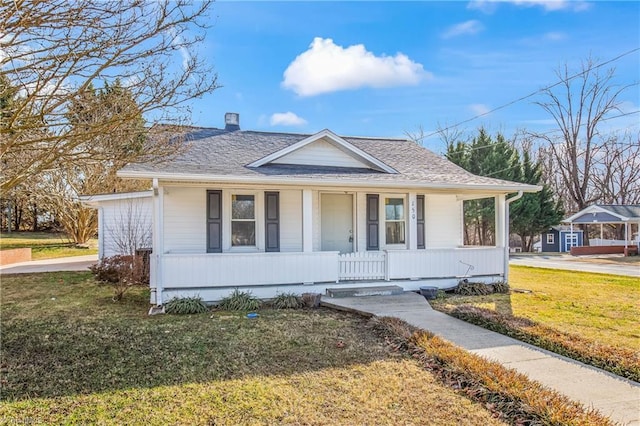 bungalow featuring covered porch and a front lawn