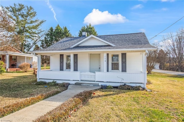 bungalow-style home with a front yard and covered porch