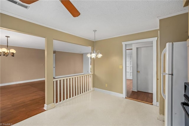 unfurnished dining area with hardwood / wood-style flooring, ornamental molding, ceiling fan with notable chandelier, and a textured ceiling