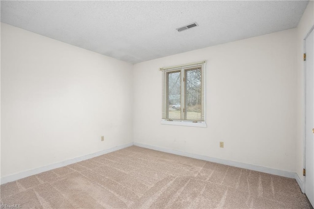 carpeted spare room with a textured ceiling