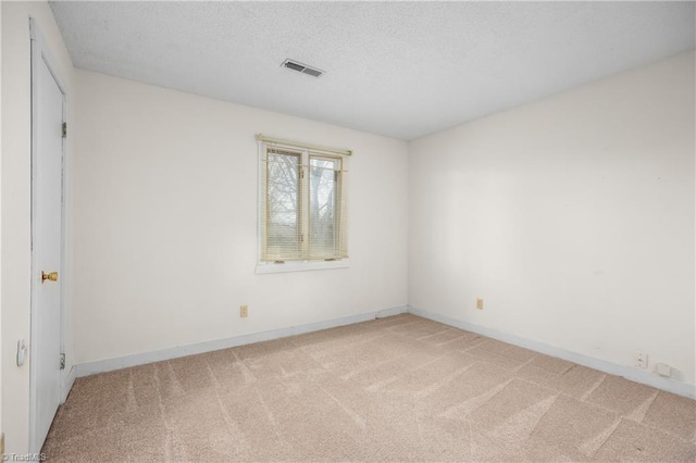 unfurnished room featuring light colored carpet and a textured ceiling