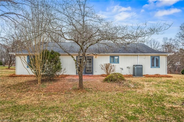 rear view of property featuring a yard and central AC