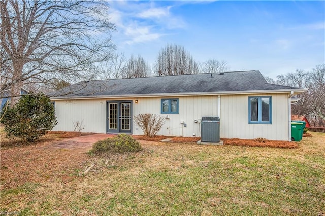 rear view of property with a yard and central air condition unit