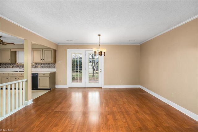 unfurnished dining area featuring crown molding, ceiling fan with notable chandelier, and light hardwood / wood-style flooring