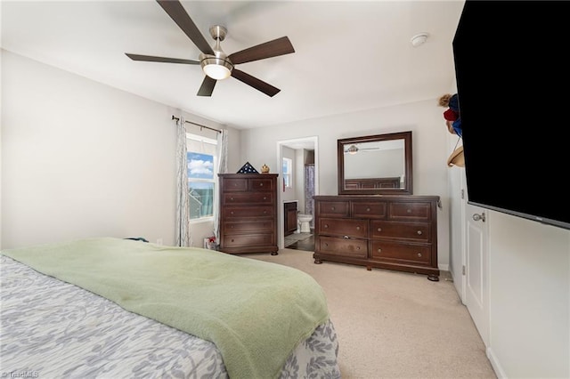 carpeted bedroom featuring ceiling fan and ensuite bath