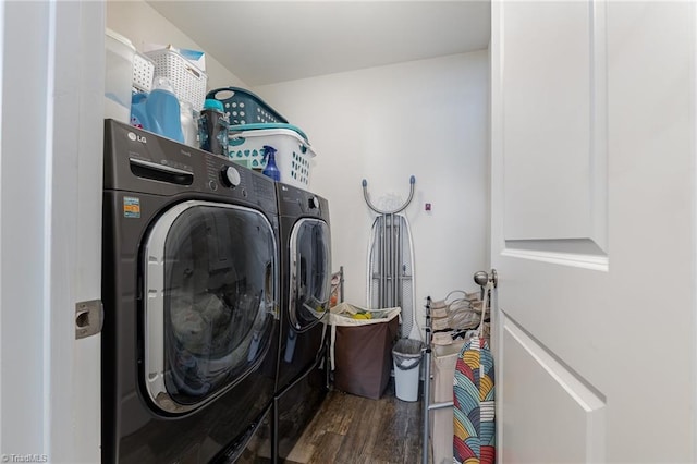 laundry room featuring washing machine and clothes dryer and dark hardwood / wood-style flooring