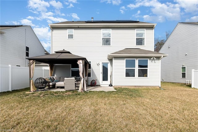 back of house featuring a yard, a gazebo, a patio, solar panels, and an outdoor hangout area