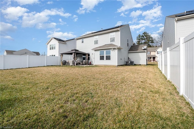 back of property featuring a yard, a gazebo, and central AC