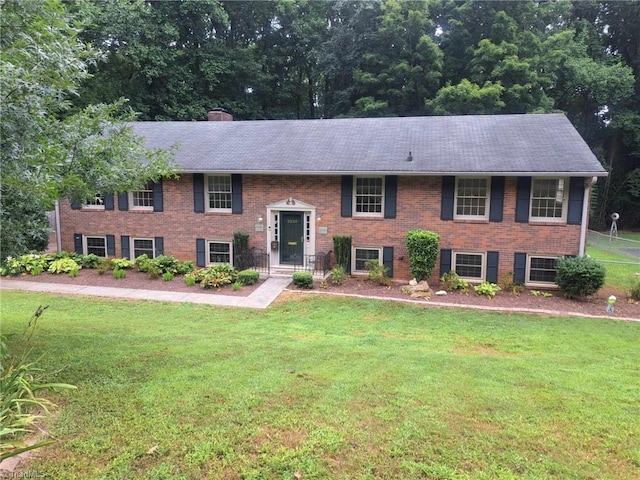 raised ranch featuring a front lawn