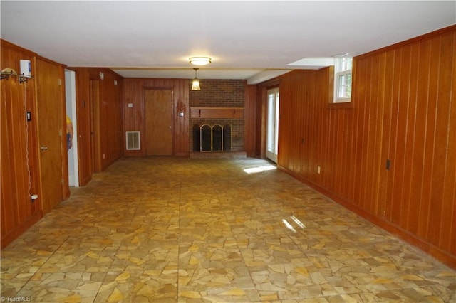 basement with a fireplace and wooden walls