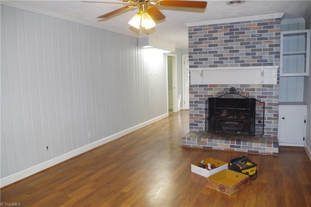 unfurnished living room featuring ceiling fan, ornamental molding, hardwood / wood-style floors, and a brick fireplace