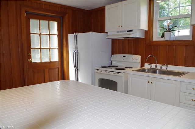 kitchen featuring white appliances, exhaust hood, white cabinetry, and a healthy amount of sunlight