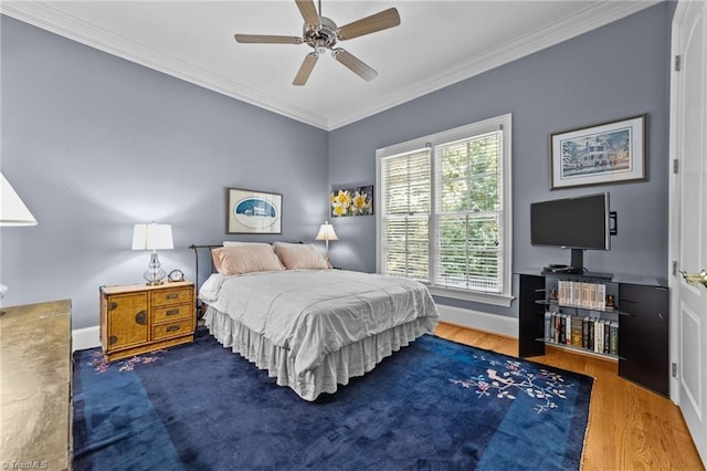 bedroom with wood-type flooring, ornamental molding, and ceiling fan