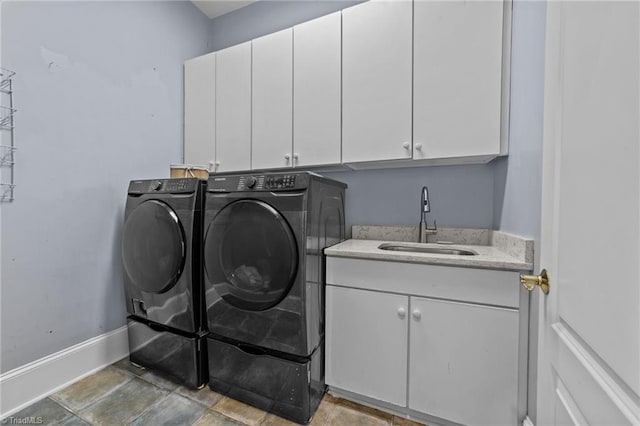 washroom with cabinets, washer and clothes dryer, and sink