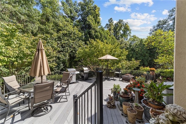 wooden terrace with area for grilling and a fire pit