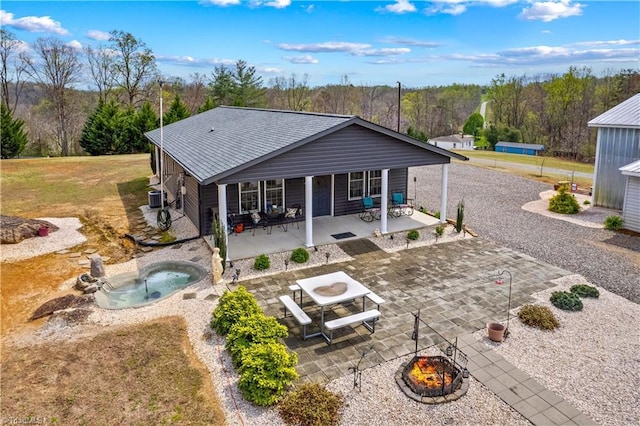 1595 Cheatham Ford Rd, Hiddenite, NC 28636 - back of property featuring central air condition unit, a patio, roof with shingles, a fire pit, and a jacuzzi