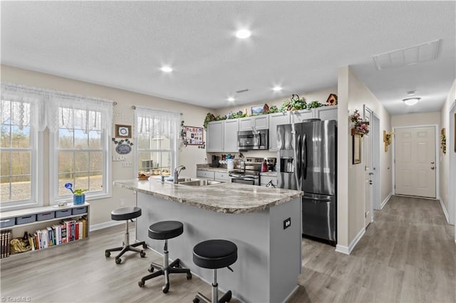 1595 Cheatham Ford Rd, Hiddenite, NC 28636 - kitchen featuring visible vents, light wood-type flooring, a breakfast bar area, and stainless steel appliances