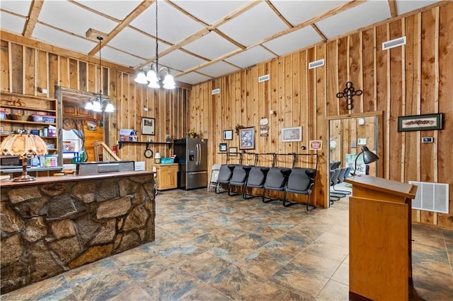 1595 Cheatham Ford Rd, Hiddenite, NC 28636 - kitchen with wood walls, stainless steel refrigerator with ice dispenser, visible vents, and hanging light fixtures