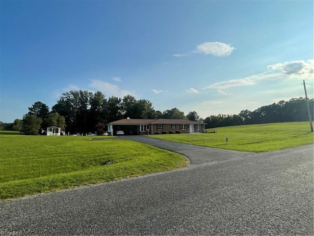 view of front of house with aphalt driveway and a front lawn