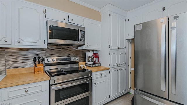 kitchen featuring decorative backsplash, white cabinetry, ornamental molding, and appliances with stainless steel finishes