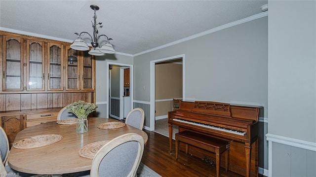 dining room with dark hardwood / wood-style flooring, an inviting chandelier, and ornamental molding