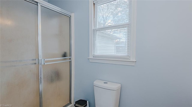 bathroom with toilet and a shower with shower door