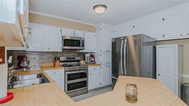 kitchen with appliances with stainless steel finishes, tasteful backsplash, white cabinetry, and sink