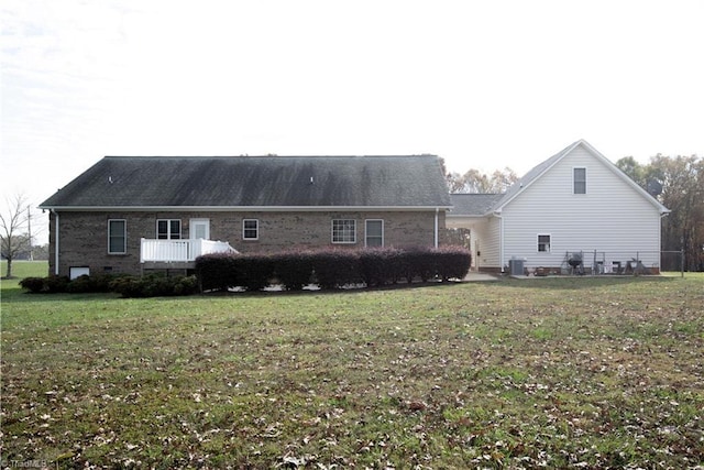 back of house with a yard and central AC