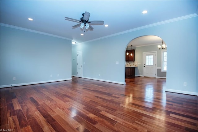 interior space featuring ceiling fan with notable chandelier, ornamental molding, and dark hardwood / wood-style flooring