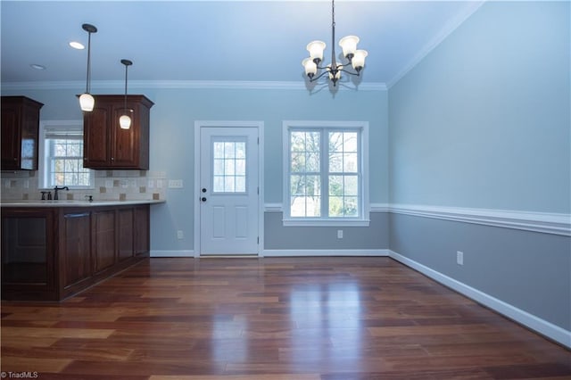 kitchen with ornamental molding, backsplash, an inviting chandelier, and pendant lighting