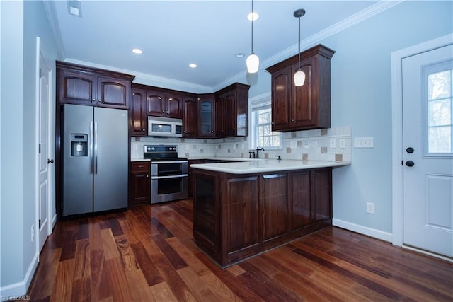 kitchen featuring appliances with stainless steel finishes, hanging light fixtures, dark hardwood / wood-style floors, kitchen peninsula, and crown molding