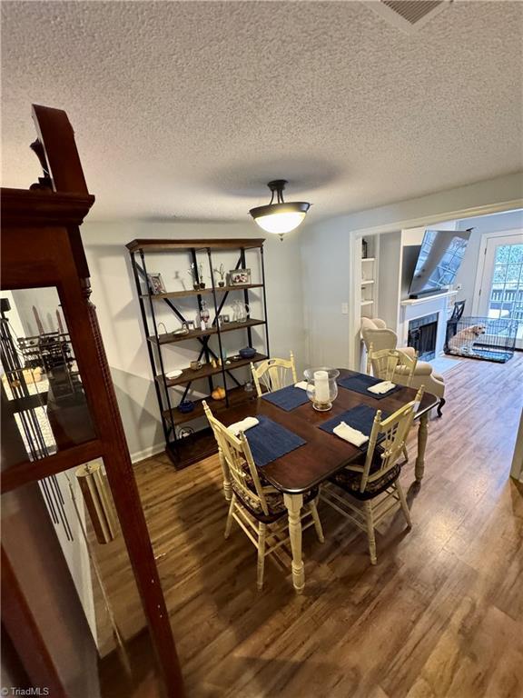 dining area with hardwood / wood-style flooring and a textured ceiling