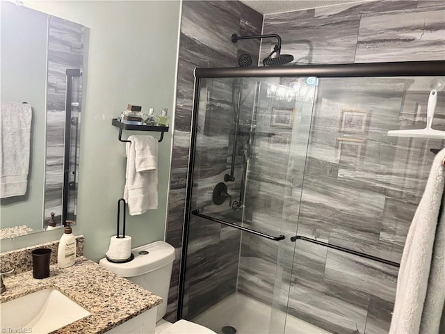 bathroom featuring vanity, an enclosed shower, and toilet