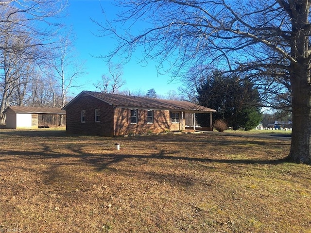 view of front of property featuring an outdoor structure and a front yard