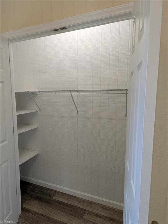 spacious closet with dark wood-style flooring