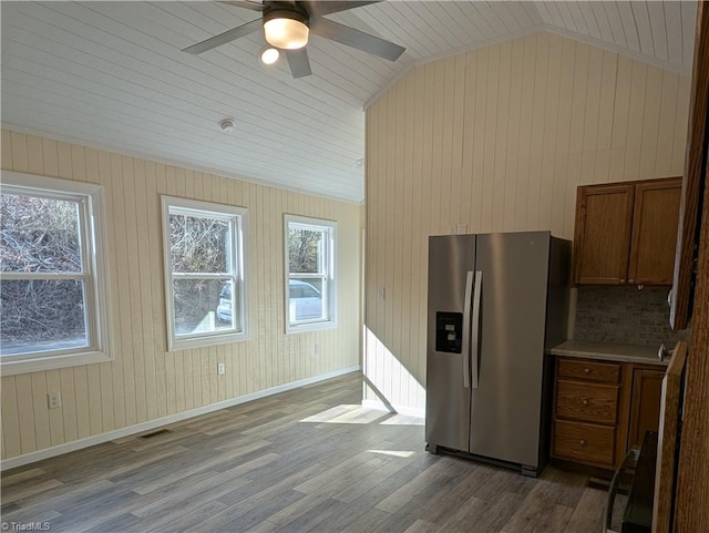 kitchen featuring stainless steel fridge, visible vents, wood finished floors, lofted ceiling, and ceiling fan