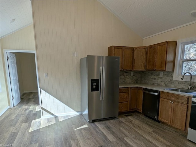 kitchen with dishwashing machine, brown cabinetry, stainless steel refrigerator with ice dispenser, wood finished floors, and a sink