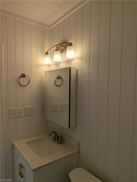 half bathroom with toilet and vanity