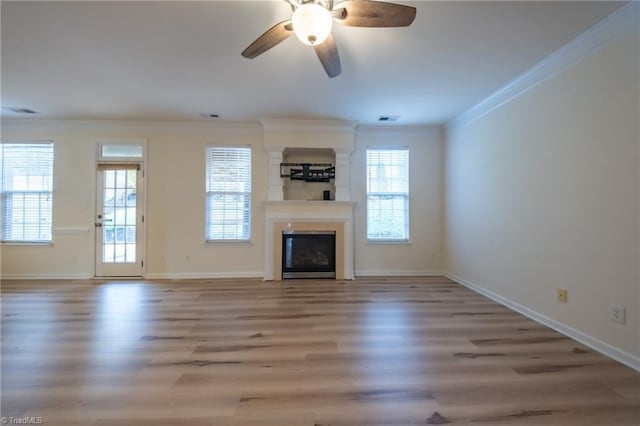 unfurnished living room with hardwood / wood-style floors, ceiling fan, and crown molding