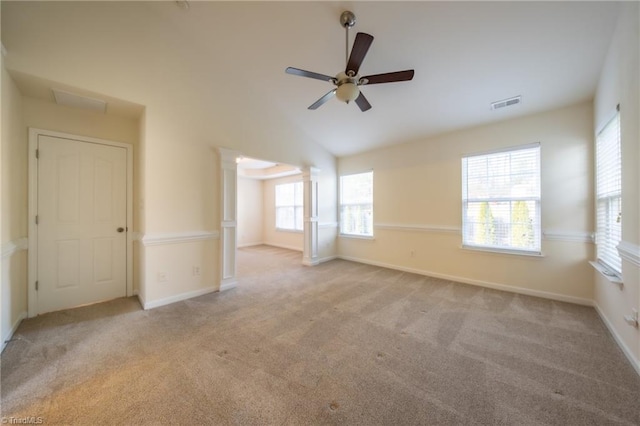 carpeted spare room with ornate columns, ceiling fan, plenty of natural light, and lofted ceiling