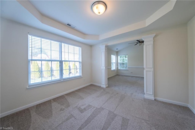 carpeted empty room featuring a tray ceiling and ceiling fan