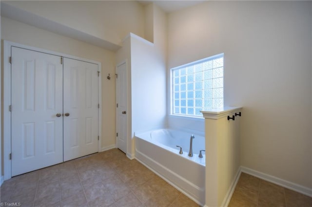 bathroom with tile patterned floors and a bath