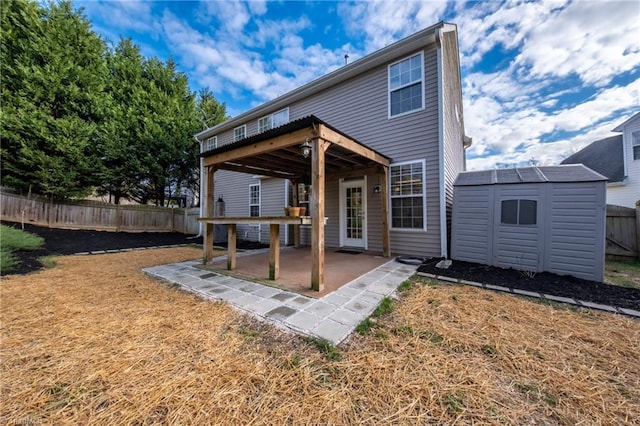 back of house featuring a deck, a patio area, and a storage shed