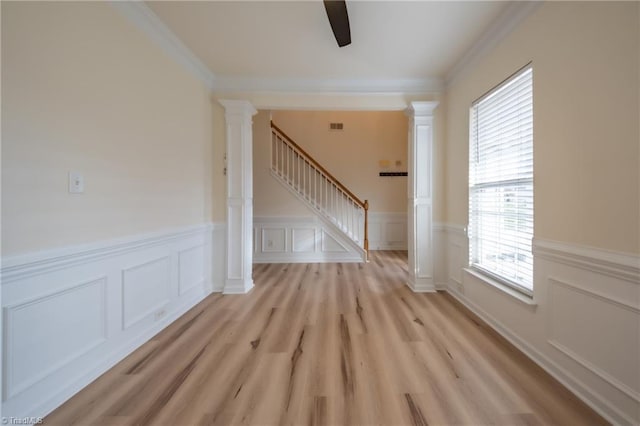 interior space featuring ornate columns, crown molding, a healthy amount of sunlight, and light wood-type flooring