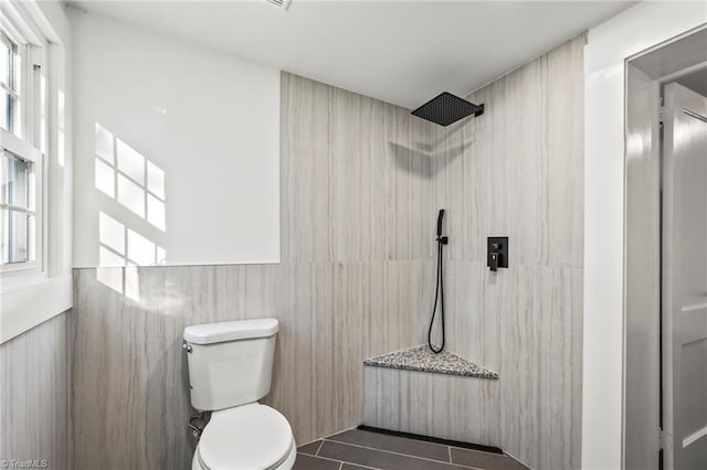 bathroom featuring toilet, tile patterned flooring, and walk in shower