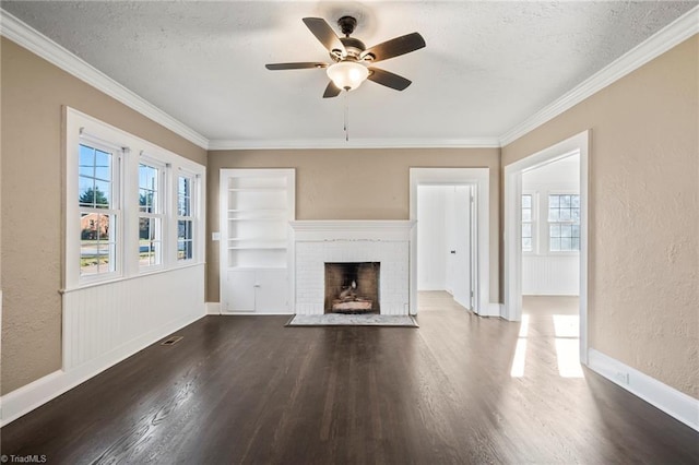 unfurnished living room featuring built in shelves, ornamental molding, a textured ceiling, and a fireplace