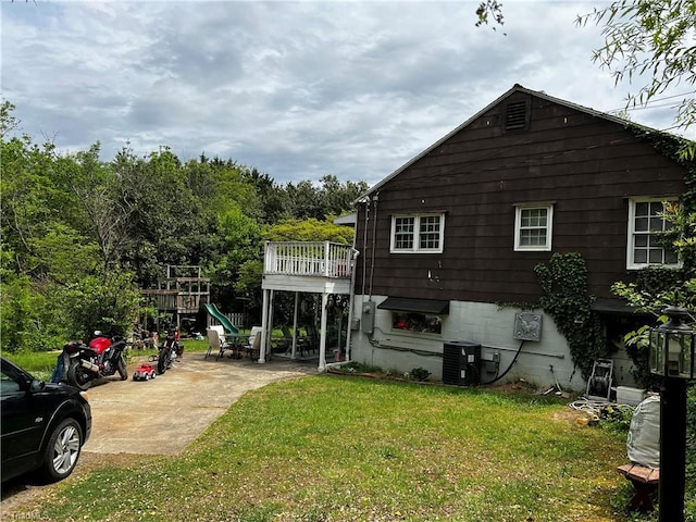 rear view of property with a yard and cooling unit