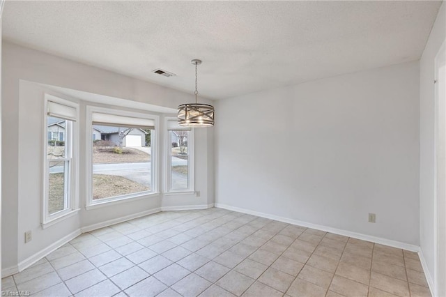 unfurnished dining area with visible vents, light tile patterned flooring, a textured ceiling, a chandelier, and baseboards